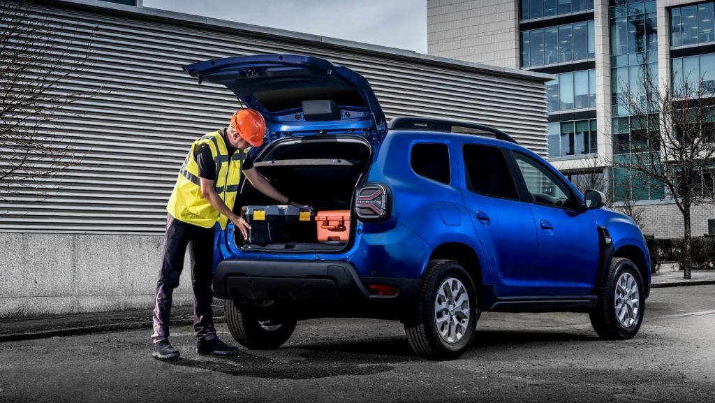 Dacia Duster Commercial with a man in hi-vis jacket loading tools into the rear loadspace