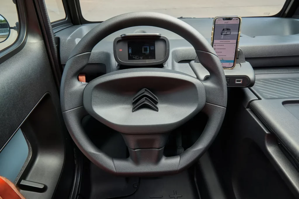 Steering wheel of Citroen Ami Cargo with mobile phone in holster