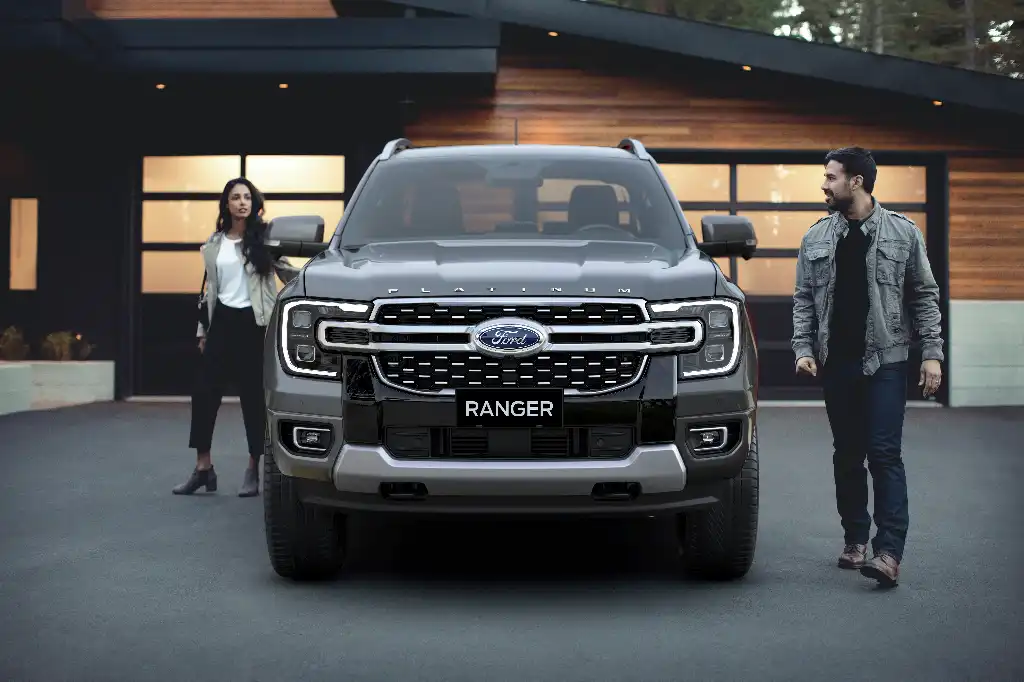 Man and a woman preparing to get into the Ranger Platinum which is head on to camera parked outside a house