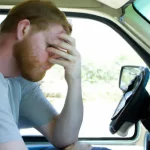 A stressed looking man in a van