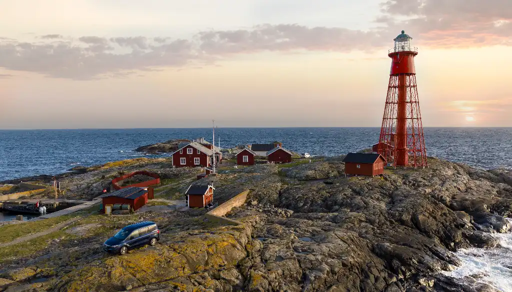 Pater Noster lighthouse, huts and harbour on the remote Hamneskar island with a car parked on it