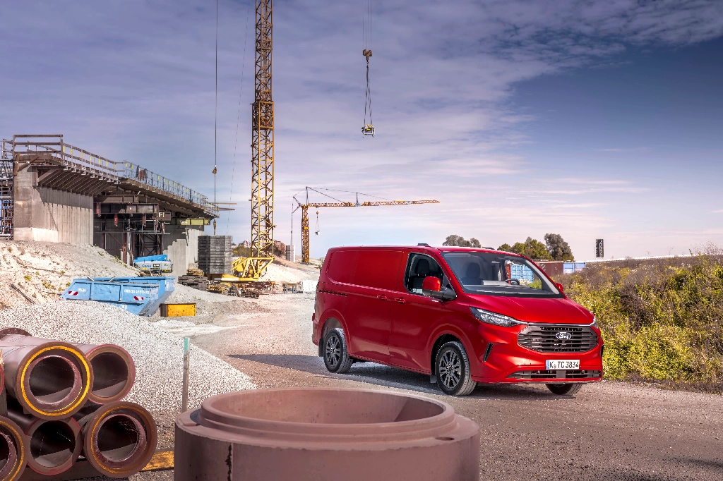 Ford Transit Custom on a building sire with ceramic piping in the foreground and cranes in the background