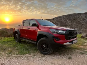 Toyota Hilux GR Sport II on a cliff top with the sun setting behind