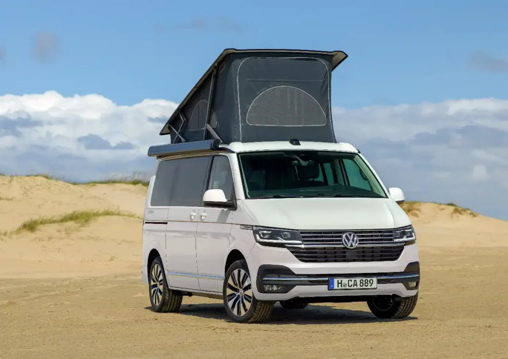 Volkswagen California in the desert with its pop-up sleeping pod roof up.